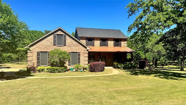 view of front facade featuring brick siding, a porch, and a front yard