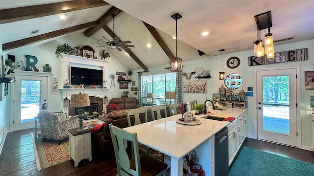 kitchen with lofted ceiling with beams, a fireplace, dark wood-type flooring, and light countertops