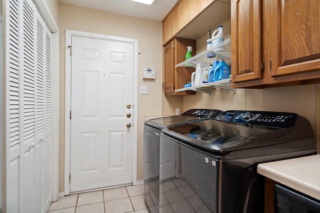 717 Van Horn Dr, Irving, TX 75060 - laundry area featuring baseboards, independent washer and dryer, light tile patterned floors, and cabinet space