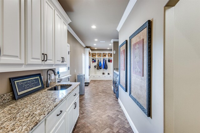 6100 Old Clarksville Rd, Reno, TX 75462 - kitchen featuring light stone counters, crown molding, a sink, brick floor, and white cabinetry