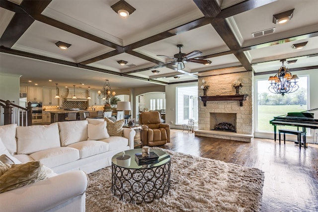 6100 Old Clarksville Rd, Reno, TX 75462 - living room with wood finished floors, ceiling fan with notable chandelier, arched walkways, coffered ceiling, and visible vents