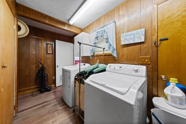 1302 E Mclennan Ave, Mart, TX 76664 - laundry room featuring wooden walls, washer and clothes dryer, and wood finished floors