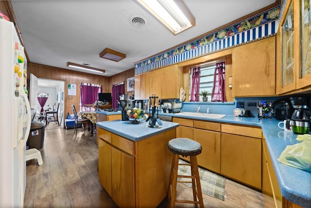 1302 E Mclennan Ave, Mart, TX 76664 - kitchen featuring white fridge with ice dispenser, a sink, a center island, hardwood / wood-style floors, and glass insert cabinets