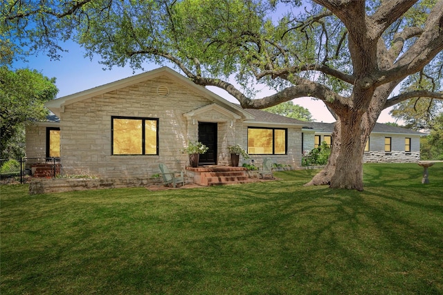 view of front of home with a front lawn and stone siding