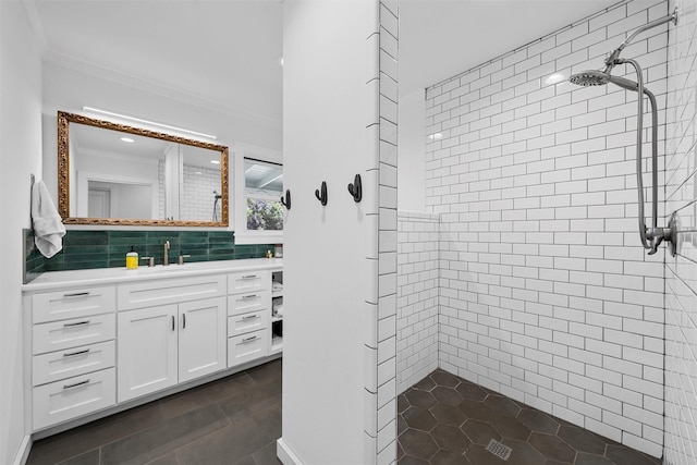 bathroom with vanity, ornamental molding, decorative backsplash, and tiled shower