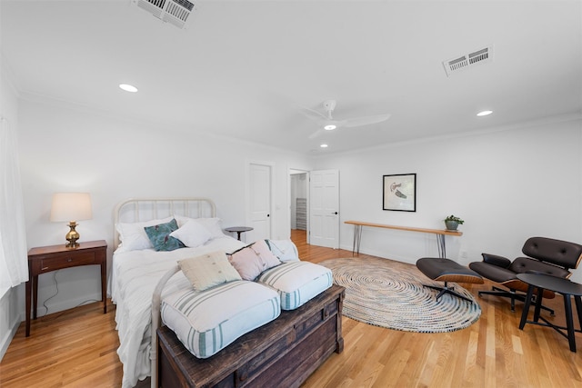 bedroom featuring crown molding, wood finished floors, and visible vents