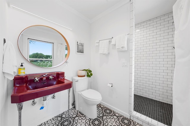 bathroom featuring crown molding, tile patterned floors, baseboards, toilet, and tiled shower