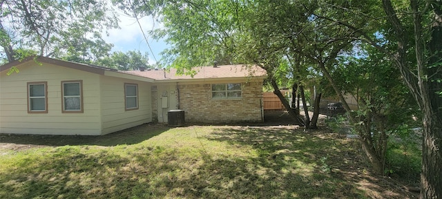 103 Lorie St, Alvarado, TX 76009 - back of property featuring brick siding, a yard, and central air condition unit