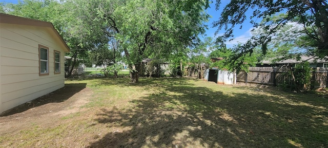 103 Lorie St, Alvarado, TX 76009 - view of yard with a fenced backyard, a storage unit, and an outbuilding