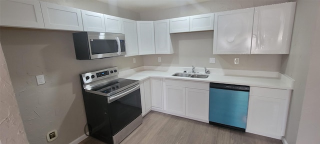 103 Lorie St, Alvarado, TX 76009 - kitchen featuring light wood-type flooring, stainless steel appliances, white cabinets, and a sink