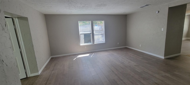 103 Lorie St, Alvarado, TX 76009 - unfurnished room with visible vents, a textured wall, wood finished floors, and a textured ceiling
