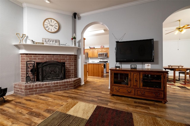 516 Hazelnut Ct, Saginaw, TX 76179 - living room featuring arched walkways, wood finished floors, a ceiling fan, ornamental molding, and a fireplace