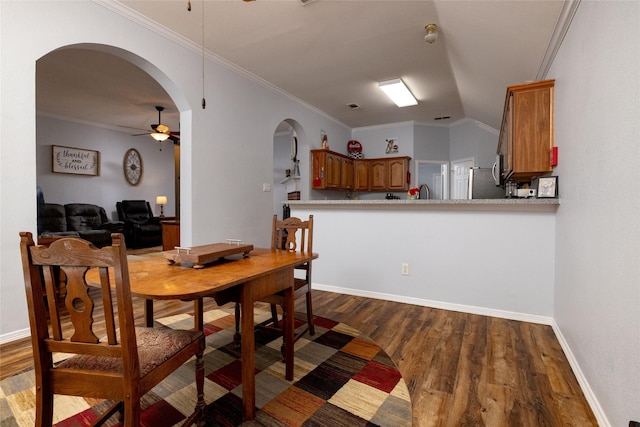 516 Hazelnut Ct, Saginaw, TX 76179 - dining space with a ceiling fan, arched walkways, dark wood-type flooring, crown molding, and baseboards