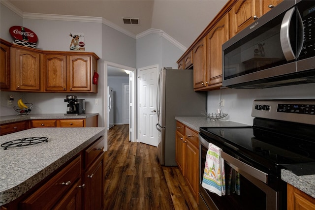 516 Hazelnut Ct, Saginaw, TX 76179 - kitchen featuring stainless steel appliances, dark wood-style flooring, brown cabinets, crown molding, and washer / dryer