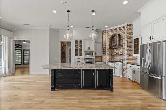 1005 Forest Lake Cir, Mckinney, TX 75072 - kitchen featuring stainless steel appliances, wall chimney range hood, dark cabinetry, light wood-style flooring, and crown molding
