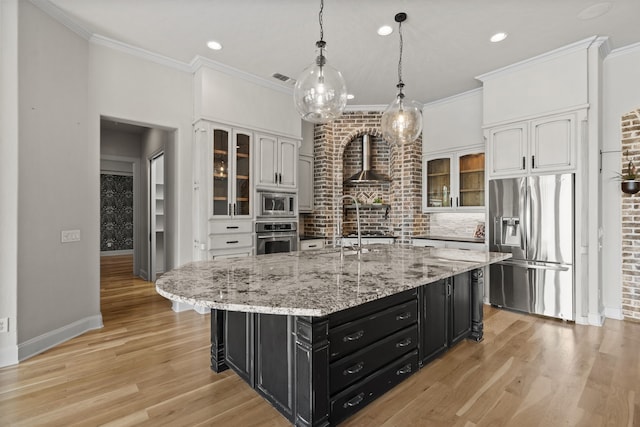 1005 Forest Lake Cir, Mckinney, TX 75072 - kitchen with appliances with stainless steel finishes, dark cabinets, white cabinetry, wall chimney range hood, and crown molding