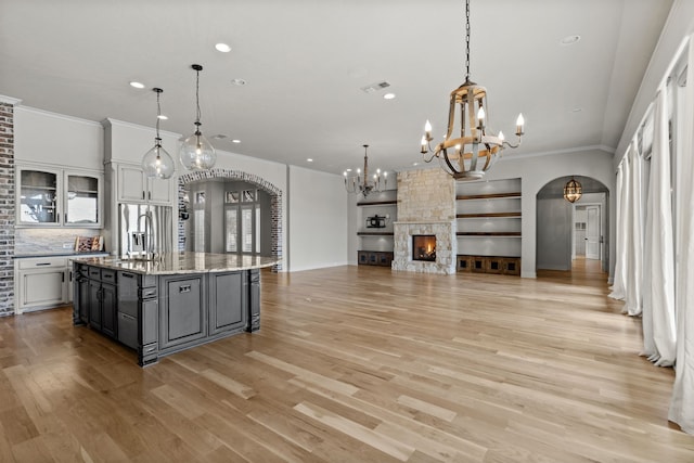1005 Forest Lake Cir, Mckinney, TX 75072 - kitchen with arched walkways, a chandelier, ornamental molding, a sink, and an island with sink