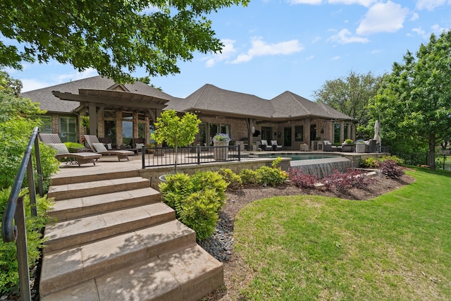 rear view of house featuring a pergola, a patio, a yard, and brick siding
