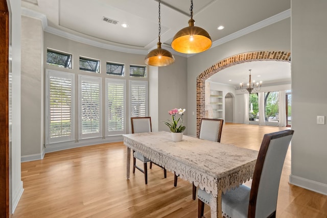 dining room with a chandelier, visible vents, ornamental molding, and light wood finished floors