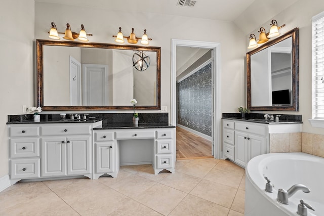 bathroom featuring vanity, baseboards, tile patterned floors, and a bath