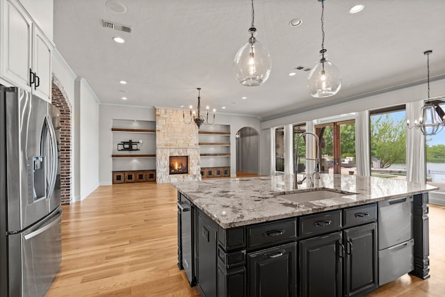 kitchen featuring a sink, appliances with stainless steel finishes, an inviting chandelier, and crown molding