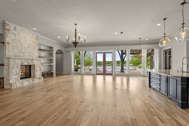 1005 Forest Lake Cir, Mckinney, TX 75072 - unfurnished living room featuring a chandelier, crown molding, a stone fireplace, built in features, and recessed lighting