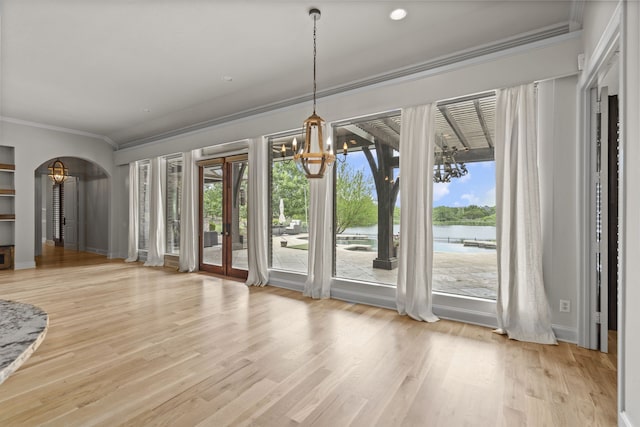 1005 Forest Lake Cir, Mckinney, TX 75072 - unfurnished dining area with a chandelier, crown molding, a water view, healthy amount of natural light, and arched walkways