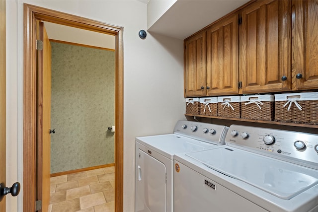 laundry area with washing machine and dryer, baseboards, and cabinet space
