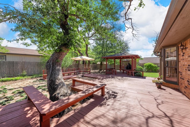 wooden terrace with a gazebo and a fenced backyard
