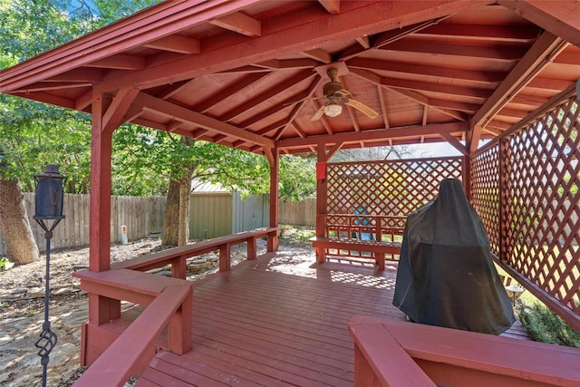 wooden terrace featuring a gazebo, a shed, a ceiling fan, a fenced backyard, and an outdoor structure