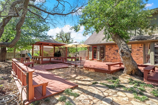 exterior space with a gazebo, outdoor dining space, and fence