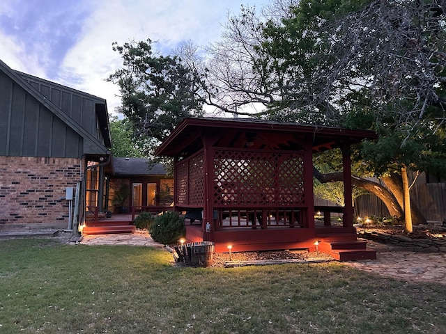 view of yard with fence, a wooden deck, and a gazebo