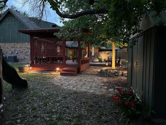 view of yard with cooling unit, a fenced backyard, and a deck