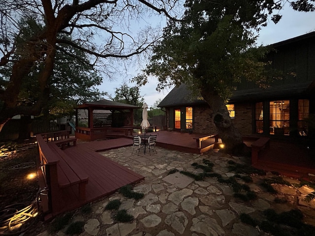 wooden terrace with a gazebo and a patio area
