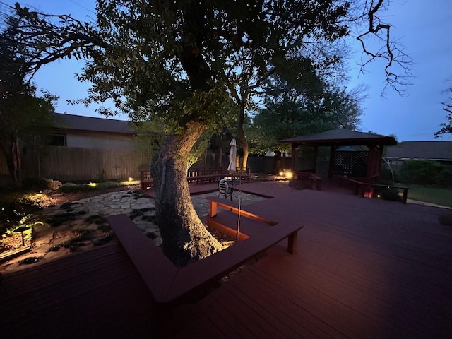 wooden terrace featuring a gazebo, a fenced backyard, and an outdoor fire pit
