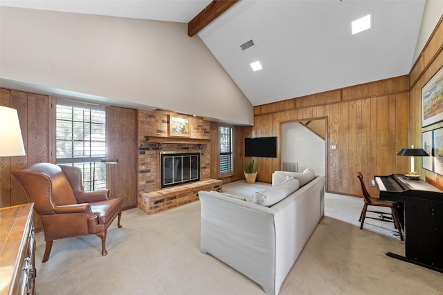 living room with wood walls, visible vents, light colored carpet, beamed ceiling, and high vaulted ceiling