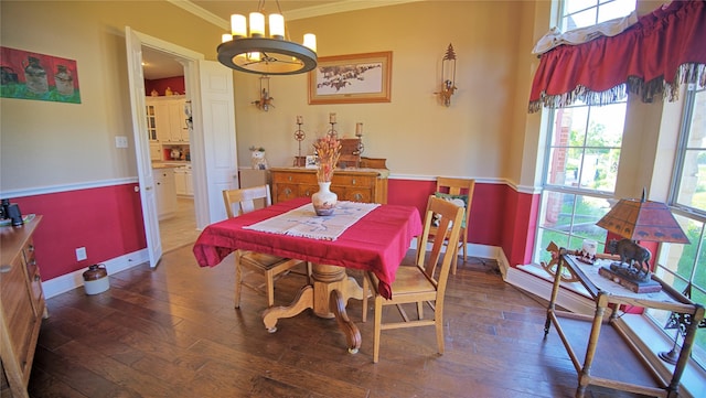 dining area featuring wood-type flooring, baseboards, plenty of natural light, and crown molding