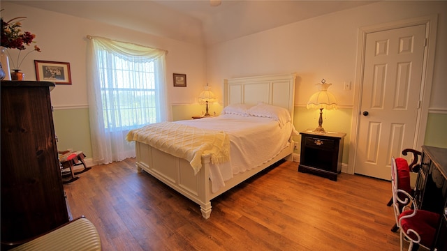 bedroom featuring vaulted ceiling, wood finished floors, and baseboards