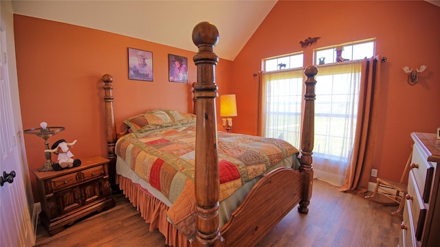 bedroom featuring lofted ceiling, baseboards, and wood finished floors