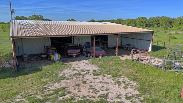 rear view of house with an exterior structure, an outbuilding, metal roof, and driveway