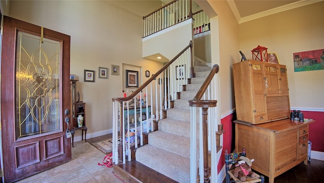interior space featuring a towering ceiling, baseboards, and ornamental molding