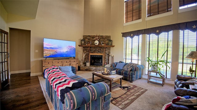 living area with baseboards, a towering ceiling, and a wealth of natural light