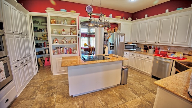 kitchen featuring white cabinets, a center island, decorative backsplash, light stone countertops, and appliances with stainless steel finishes