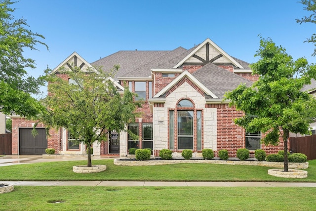 13002 Clarendon Dr, Frisco, TX 75035 - view of front of house featuring roof with shingles, fence, stone siding, brick siding, and a front yard