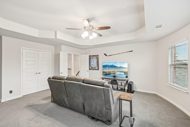 13002 Clarendon Dr, Frisco, TX 75035 - carpeted living room with visible vents, baseboards, a raised ceiling, and ceiling fan