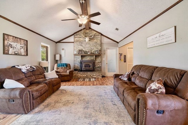living area featuring vaulted ceiling, wood finished floors, visible vents, crown molding, and ceiling fan