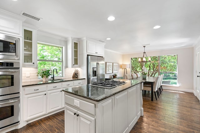 6726 Williamson Rd, Dallas, TX 75214 - kitchen with appliances with stainless steel finishes, a sink, ornamental molding, tasteful backsplash, and white cabinets