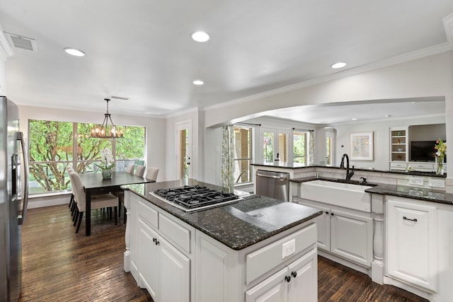 6726 Williamson Rd, Dallas, TX 75214 - kitchen featuring a sink, appliances with stainless steel finishes, arched walkways, a kitchen island, and a chandelier