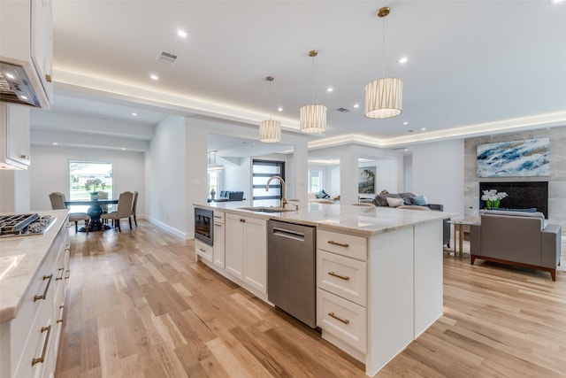 kitchen featuring stainless steel appliances, open floor plan, visible vents, and a sink