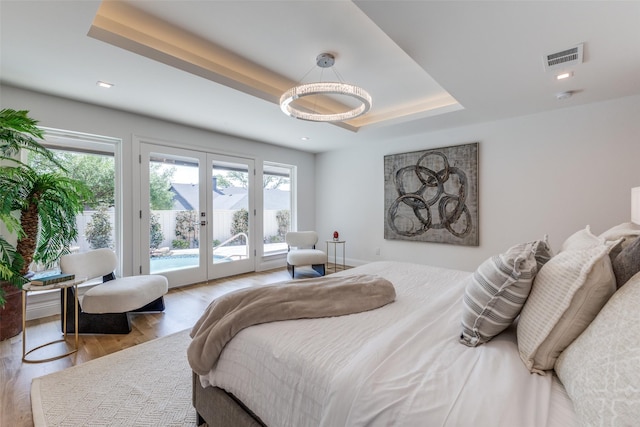 bedroom featuring french doors, access to exterior, wood finished floors, and multiple windows